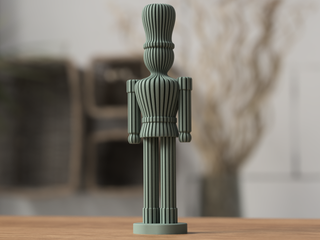 A red wooden nutcracker figurine stands on a wooden surface.