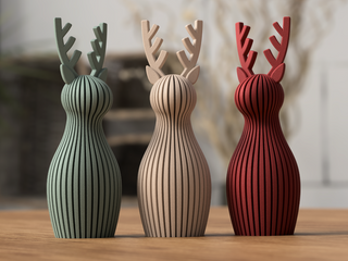 A red, striped reindeer sits on a wooden surface.